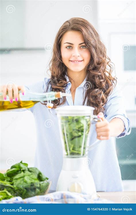 Woman Making Vegetable Soup Or Smoothies With Blender In Her Kitchen