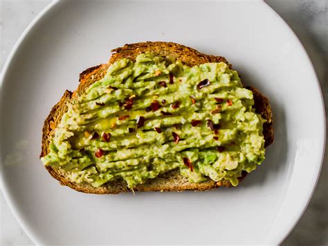 Mashed Avocado Spread Over Crusty Whole Wheat Bread With Olive Oil Red