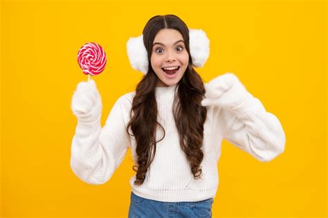 Premium Photo | Funny child with lollipop over yellow isolated ...