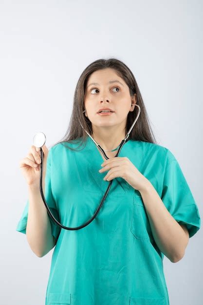 Retrato de un médico joven con estetoscopio en uniforme Foto Gratis