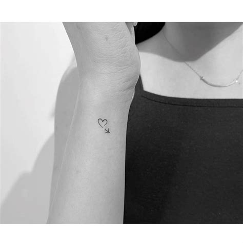 Minimalist Airplane And Heart Tattoo On The Wrist