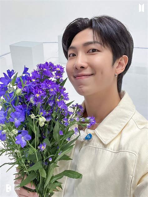 A Man Holding A Bouquet Of Purple Flowers