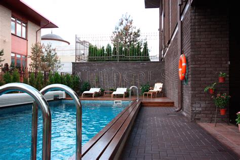 Уличный бассейн с покрытием и водопадом в частном доме