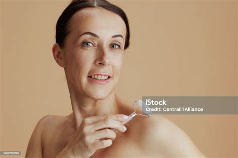 Portrait Of Happy 40 Years Old Woman Against Beige Background Stock