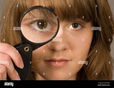 A Young Woman In Her Twenties Looking Through A Magnifying Glass Stock