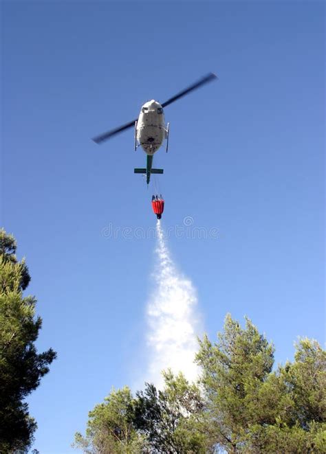 Firefight Helicopter Dropping Water Over Fire On A Forest Editorial