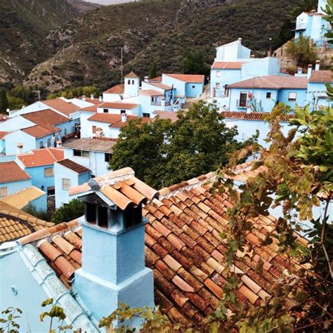 Blue Buildings With Tiled Roofs In The Mountains