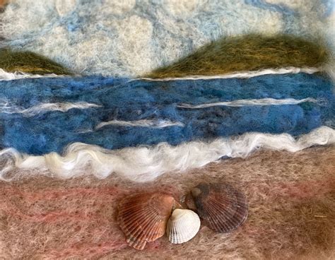 There Is A Sea Shell On The Ground Next To Some Blue And White Wools