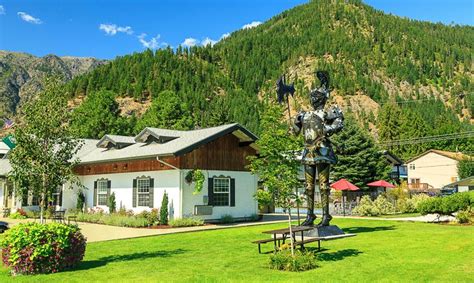 there is a statue in front of a house with mountains in the backgroud