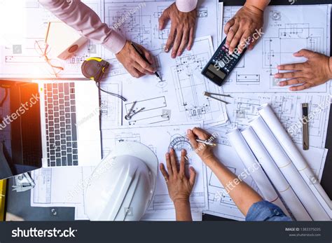 Engineers Pointing Building On Blueprint Using Stock Photo 1383375035