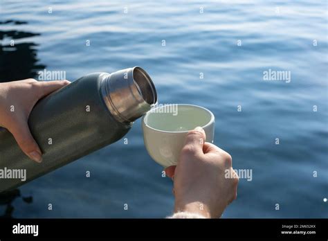 Woman S Hand Pouring Hot Drink From Thermos Into Glass While Pouring A Drink From A Thermos