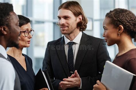 Un Hombre De Negocios Apuesto Y Sonriente Hablando Con Un Grupo De