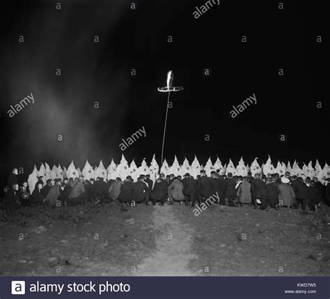 Ku Klux Klan Gathering With Fully Robed And Hooded Members And Kneeling