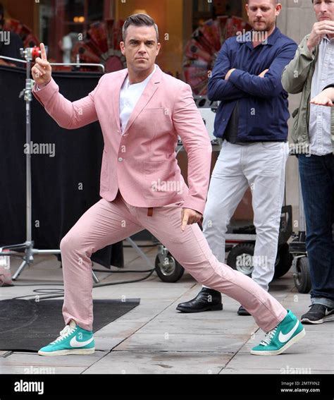 Wearing A Pink Suit With Baby Blue Nike Sneakers Robbie Williams And