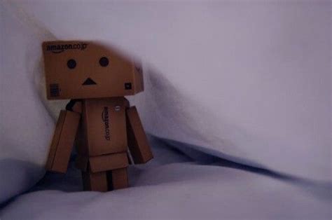 A Brown Paper Toy Standing In The Snow With Its Head Turned To Look