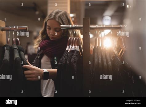 Beautiful Woman Selecting Dress From Rack Stock Photo Alamy