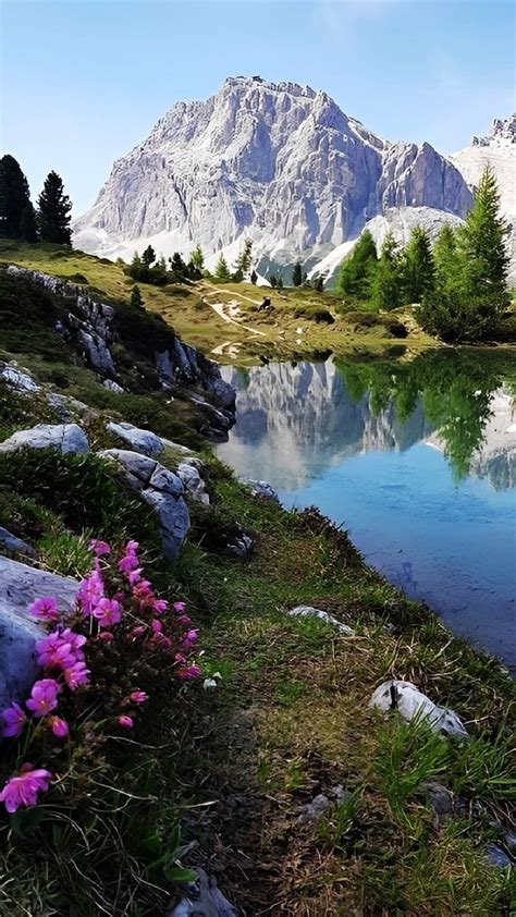 The Mountains Are Reflected In The Still Water Of This Mountain Lake