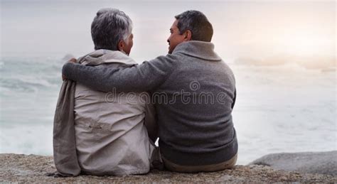 Senior Couple Hug And Back At Beach With Sunset Waves And Relax On