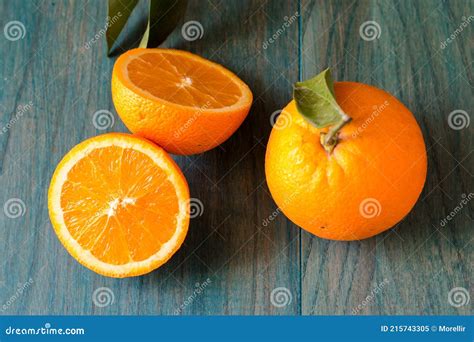 Naranja Cortado Por La Mitad Y Otras Naranjas Sobre Fondo De Madera De