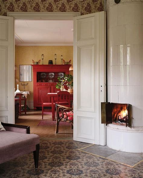 An Open Door Leading To A Living Room With A Fire Place In The Center