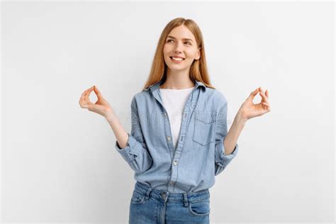 Young Woman Standing In Meditative Pose Enjoying Peaceful On White