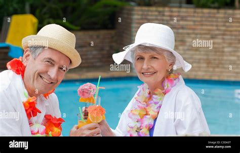 Happy Senior Couple Drinking Cocktails And Toasting Each Other Stock