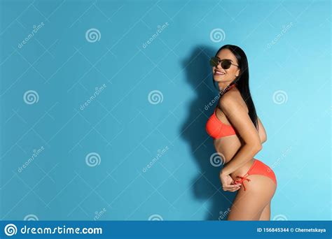 Hermosa Joven En Bikini Elegante Con Gafas De Sol De Fondo Azul Claro