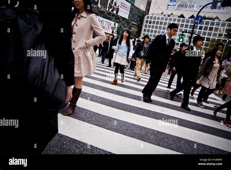 People Cross A Zebra Crossing In The Shinjuku Area Of Tokyo Japan