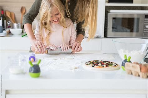 Mother And Daughter Using A Rolling Pin In The Kitchen By Stocksy