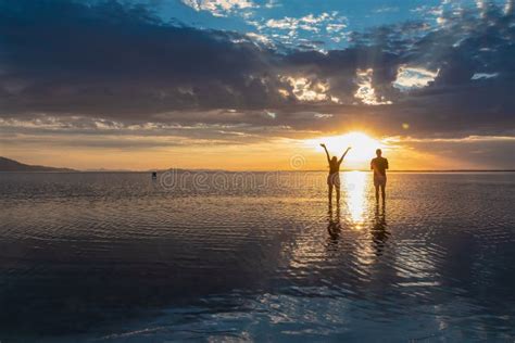 Silhouette Of Loving Couple Walking At Sunrise On The Salt Lake Of