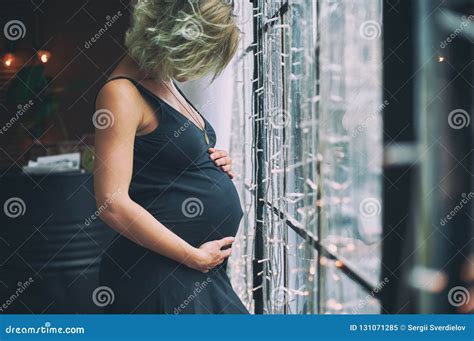 Young Beautiful Pregnant Woman Standing Near Window At Loft Style Home