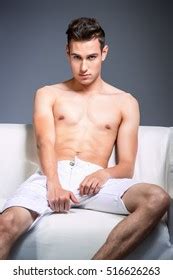 Handsome Shirtless Man Sitting On Couch Stock Photo