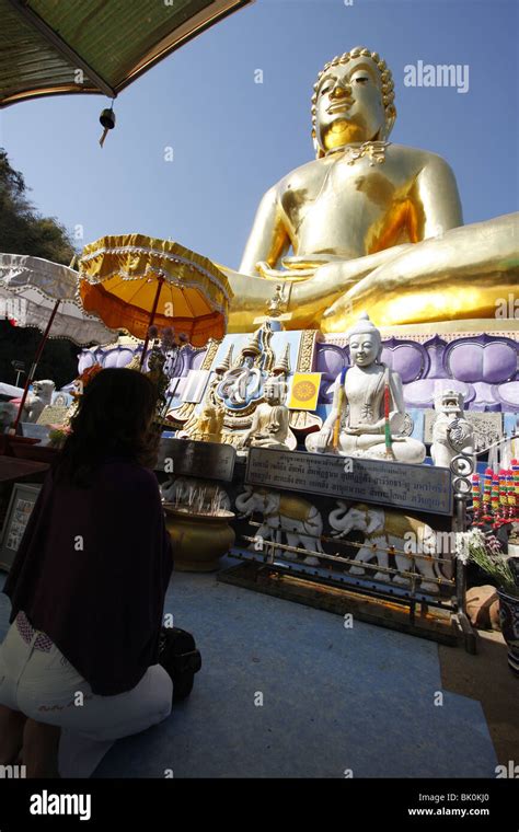 A Woman Prays In Front Of A Giant Gold Buddha At Sop Ruak The Golden