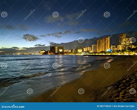 Serene Waikiki Beach At Night With A Stunning City Skyline In The