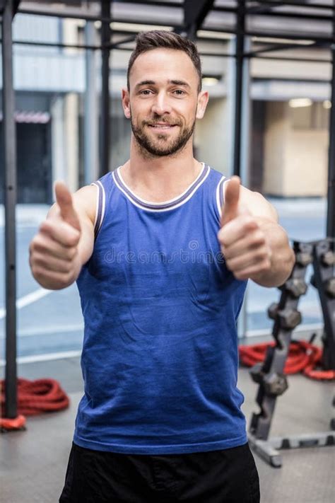 Hombre Muscular Que Muestra Los Pulgares Para Arriba Foto De Archivo