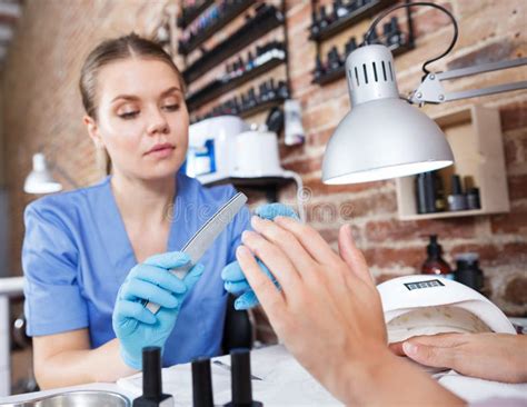 Manicurist Girl Polishing Nails To Female Client In Salon Stock Photo