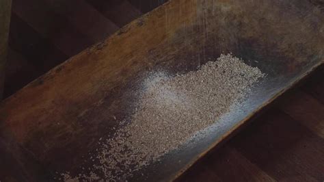 The Ancient Quern Stone Hand Mill With Grain The Man Grinds The Grain