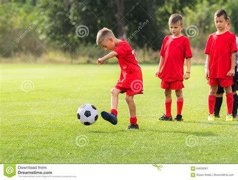 Menino Que Retrocede A Bola De Futebol No Treinamento Imagem De Stock