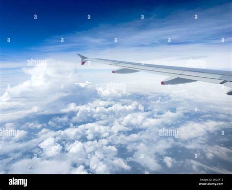 View of clouds and aircraft wing through window of British Airways ...