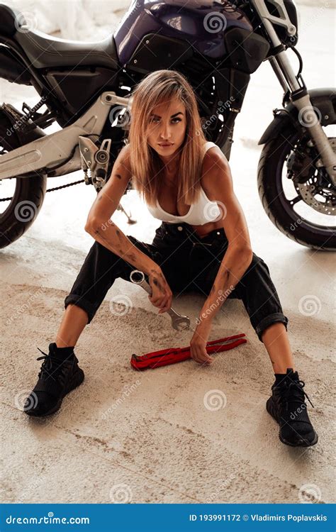 Hot Looking Girl With Wrenches Posing With A Sport Motorcycle Stock