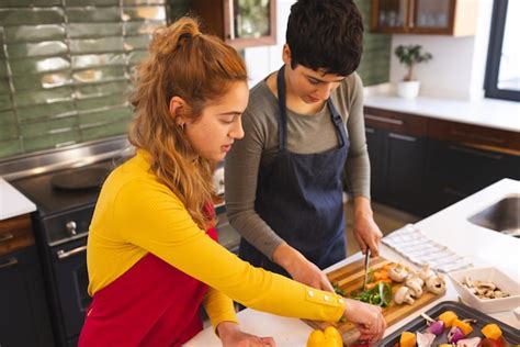 Premium Photo Focused Biracial Lesbian Couple Cooking Chopping Vegetables In Kitchen At Home