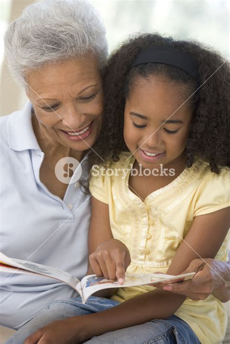 Grandmother And Granddaughter Reading And Smiling Royalty Free Stock