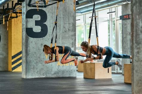 Deux Jeunes Filles Athlétiques Faisant De L Exercice Avec Des Sangles De Fitness Trx Au Gymnase