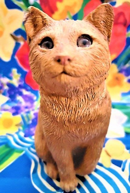 A Cat Figurine Sitting On Top Of A Blue And White Table Cloth With