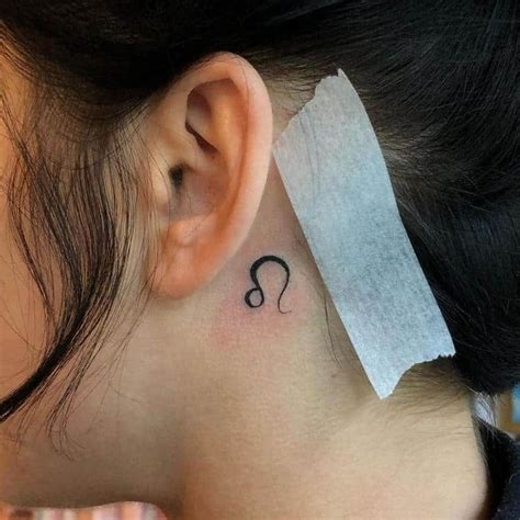 A Womans Behind The Ear Tattoo Has A Question Mark On It