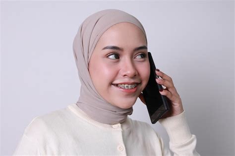 Asiatisches muslimisches Mädchen im Hijab und mit Zahnspangen das mit