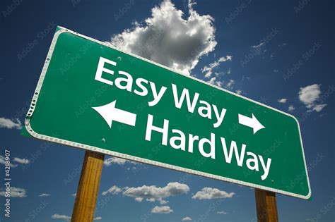 Easy Way Hard Way Road Sign With Dramatic Blue Sky And Clouds Stock