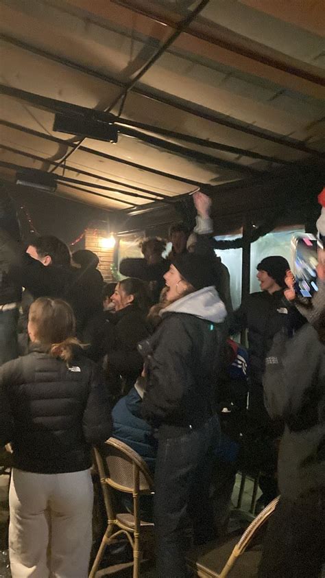 A Group Of People Standing Around Each Other In Front Of A Building