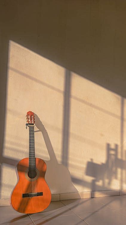 Brown Guitar on White Wall · Free Stock Photo