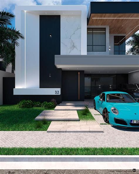 A Blue Sports Car Is Parked In Front Of A Modern House With Grass And